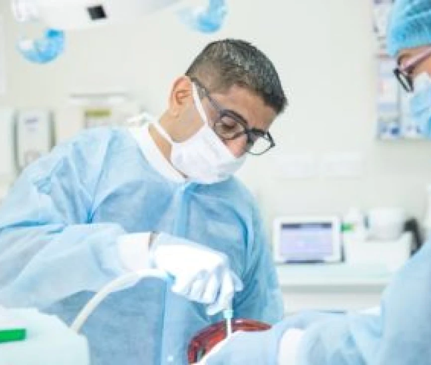Dr. Shalji attending to a patient in a dental clinic