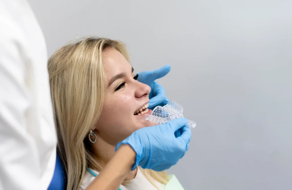 Orthodontist making a teeth impression mold in a patient's mouth.
